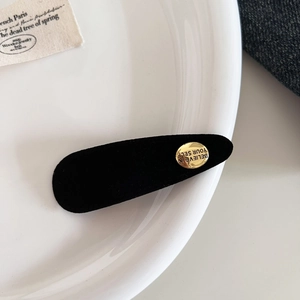 Detail der schwarzen beflockten Haarklammer mit goldener 'Believe in Yourself' Plakette