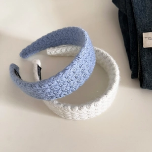 Detail of knitted headbands in blue and beige with thick woven texture and cozy style