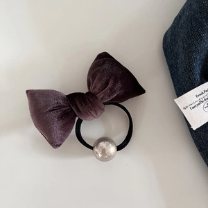 Detail of elegant velvet hair tie featuring a pearlescent bead and high-stretch elastic band