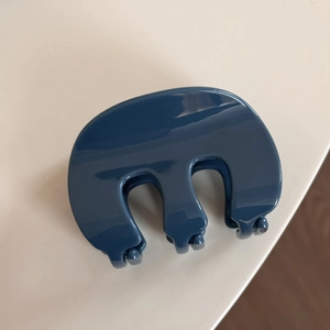 Détail de la pince à cheveux bleu marine brillante montrant sa structure à trois dents