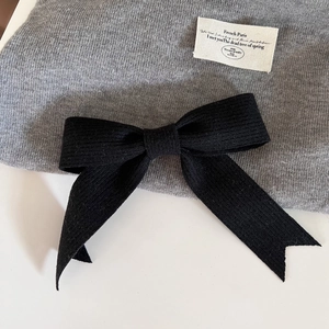 Détail d'un nœud papillon en tricot noir avec étiquette en tissu French Paris