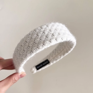 Close-up of knit mohair headband featuring a white wool texture and handmade woven label