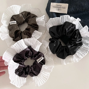 Détail de trois chouchous en cuir de style français avec bords plissés et étiquettes faites main