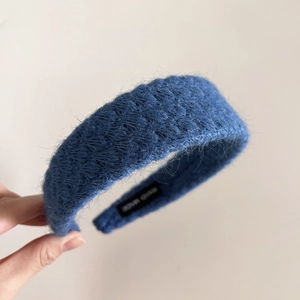 Detailed view of the soft dark blue mohair headband with a woven Handmade label