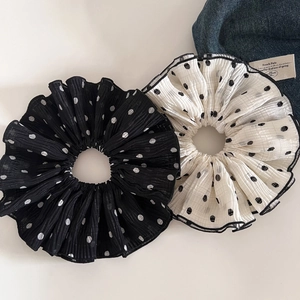 Detail of large double-layered polka dot scrunchie with ruffled fabric texture