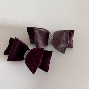 Detailed close-up of velvet bow hair clips with multi-layered pearl accents in two colors