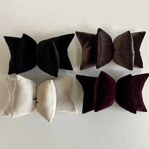 Close-up of vintage velvet bow hair clips in black, gray, cream, and wine red