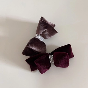 Detail of velvet bow hair clips with triple-row pearl inlay in dark coffee and wine red