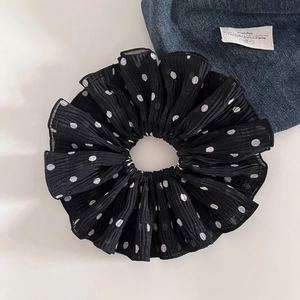Close-up of a double-layered black polka dot chiffon hair scrunchie with pleated texture