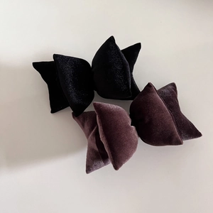 Detail view of plush 3D velvet bow hair clips in black and dark brown colors