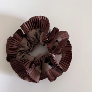 Detailed view of the double-layered chestnut brown satin pleated hair scrunchie design
