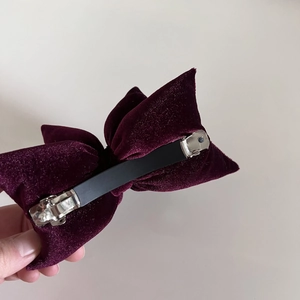 Detailed back view of the burgundy velvet bow hair clip with silver metal spring fastener
