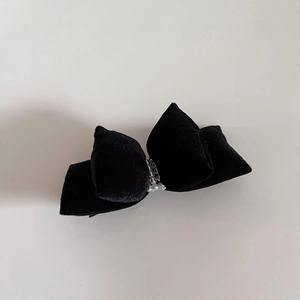 Detail of velvet bow hair clip featuring elegant pearls and metal duckbill clip
