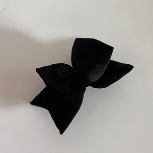 Detailed close-up of double-layered black velvet bow hair clip with soft padded texture