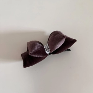 Close-up of a purple velvet bow hair clip with luxury white pearl bead embellishments