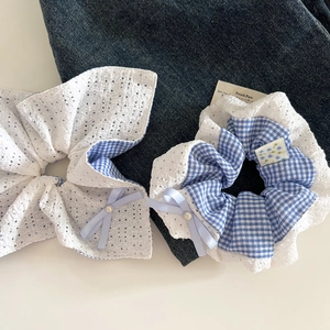 Détails de chouchous à carreaux bleus et dentelle blanche avec nœud et perle