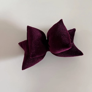 Macro detail of plush deep purple velvet bow hair clip with French vintage design