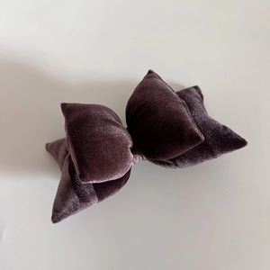 Detailed macro view of the chocolate velvet fabric texture on a plump layered bow hair clip