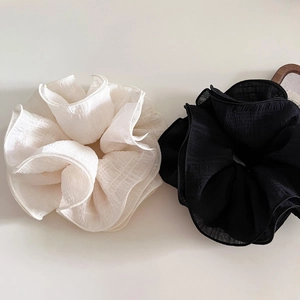 Detail view of large white and black ruffled scrunchies with elegant textured bubble fabric