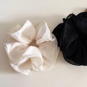 Detail of oversized 4-layer ruffled scrunchies set in black and creamy white chiffon fabric