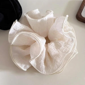 Close-up of white layered pleated scrunchie with detailed chiffon texture and soft ruffles