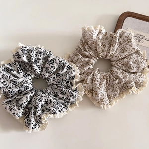 Détail de chouchous fleuris surdimensionnés avec dentelle rétro en gris et beige