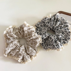 Détail de chouchous à fleurs avec bordure en dentelle en beige et motifs variés