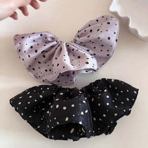 Détail de chouchous en satin à pois lavande et noirs pour queues de cheval hautes