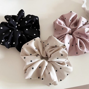 Three-piece satin floral scrunchies set in black, pink, and cream with daisy patterns