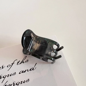 Macro detail of marble pattern hair claw clip with golden La France elegant lettering