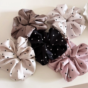 Detailed set of five satin floral scrunchies in coffee, black, and pastel colors