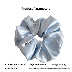 Detail view of large blue satin scrunchie showing 20cm diameter and silky texture