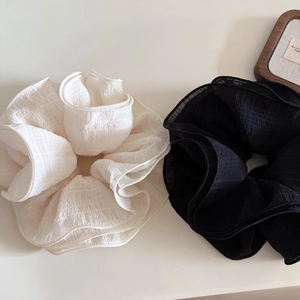 Set of two oversized layered scrunchies in cream and black with pleated fabric texture