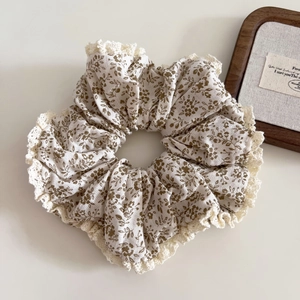 Détail d'un chouchou floral surdimensionné avec motif olive et bordure dentelle