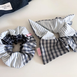 Detail of blue striped and plaid patchwork scrunchies with handmade fabric labels