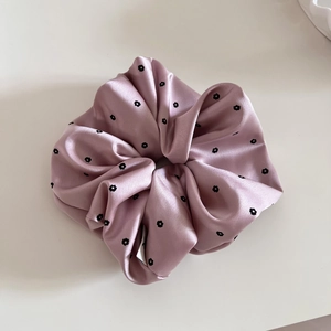 Detail of satin scrunchie with floral print and silky texture for low ponytails
