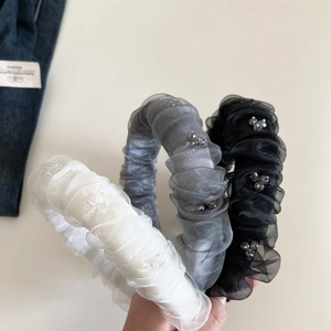 Détail de serre-tête plissé en organza avec perles délicates en noir, gris et blanc