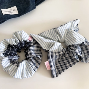 Detail of blue striped and checkered fabric hair scrunchies with pink brand tags