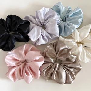 Detail showing set of six colorful glossy satin scrunchies with elegant silk texture