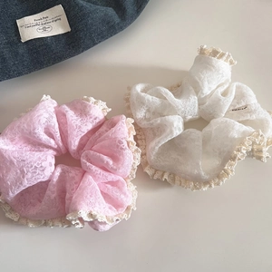 Close-up of pink and white lace scrunchies with elegant crochet floral edges