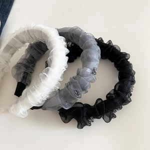 Gros plan de serre-têtes en organza plissé noir gris et blanc avec détails strass