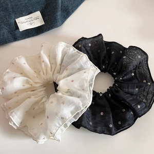 Detail of oversized polka dot organza hair scrunchies in black and beige sets