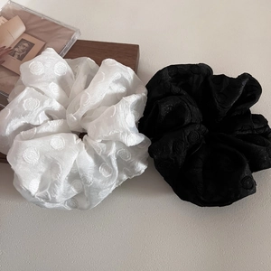 Detail view of large white and black mesh scrunchies with elegant jacquard polka dots