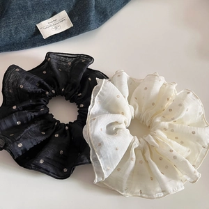 Detailed view of oversized mesh scrunchies with elegant gold polka dots and fine edging