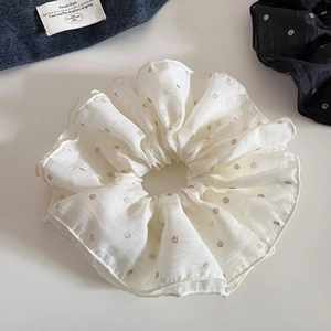 Detail of white mesh scrunchie with gold polka dots and delicate pleated tulle texture