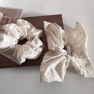 Beige floral embroidered lace scrunchie and bow set on vintage wooden tray