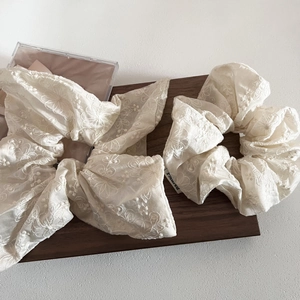 Detailed close-up of beige embroidered lace scrunchie and long ribbon hair tie set