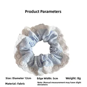 Dettaglio di scrunchie a quadretti azzurri con bordo in pizzo, diametro 12 cm e tessuto