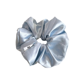 Elegant light blue satin scrunchie with soft silk luster and branded bow label tag