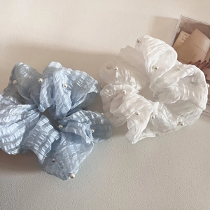 Détail de chouchous en seersucker bleu et blanc avec perles et texture quadrillée